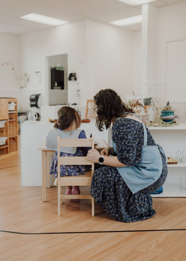 A guide and child work together at the table