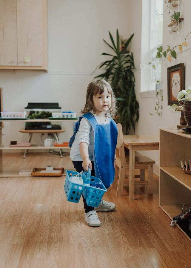 Carrying a basket of work across the classroom