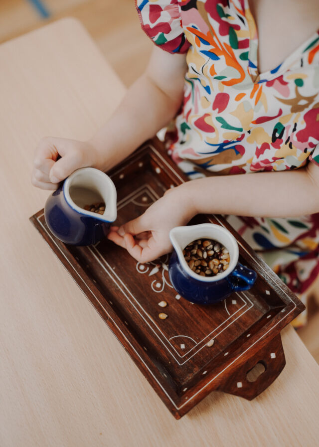 Pouring beans between little jugs