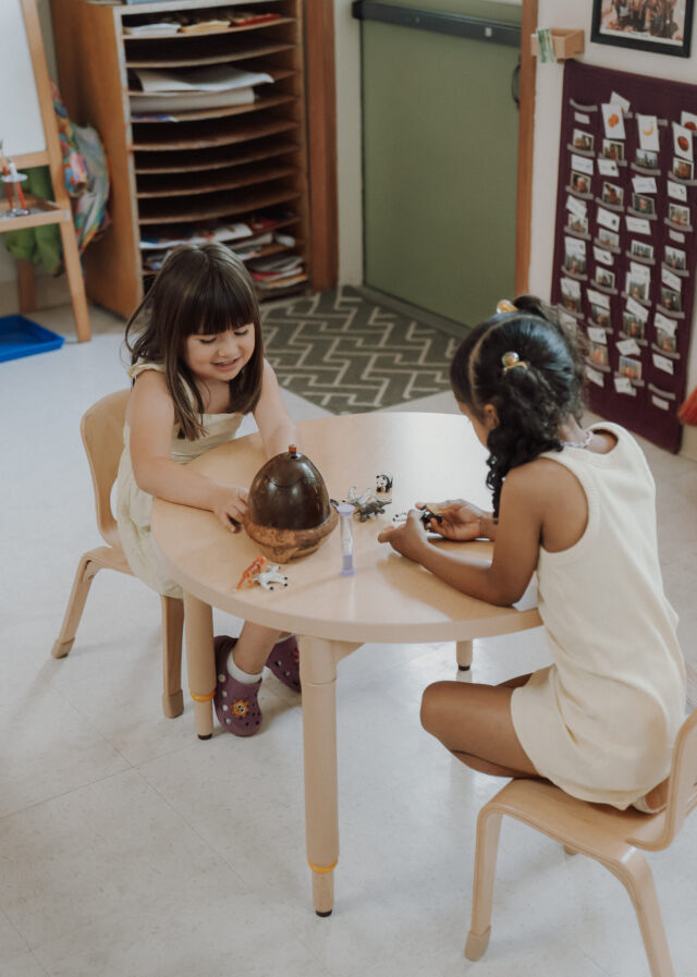 Two friends work together at the little table