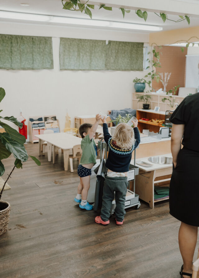 Toddlers gather around a guide