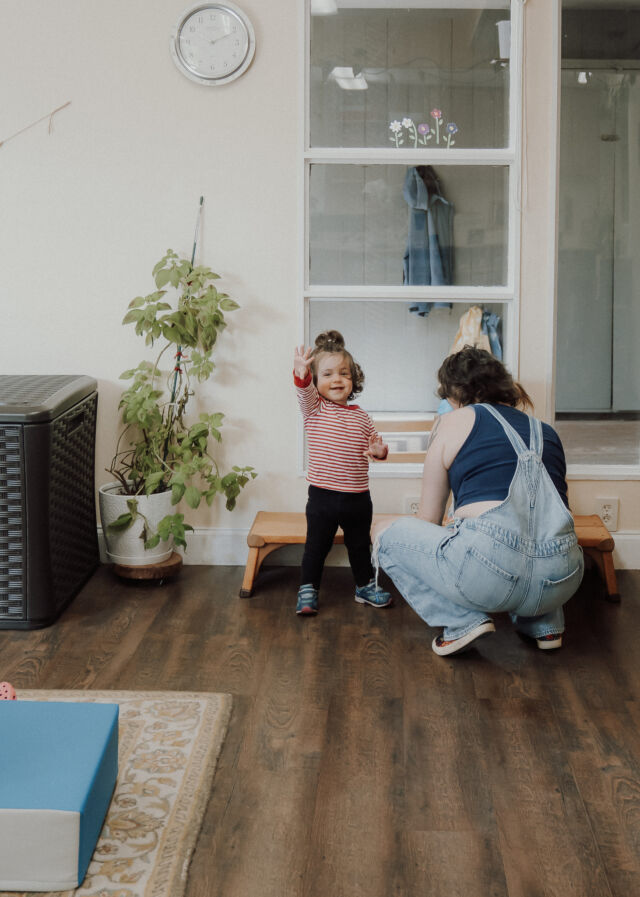 A guide kneels to a toddler's level