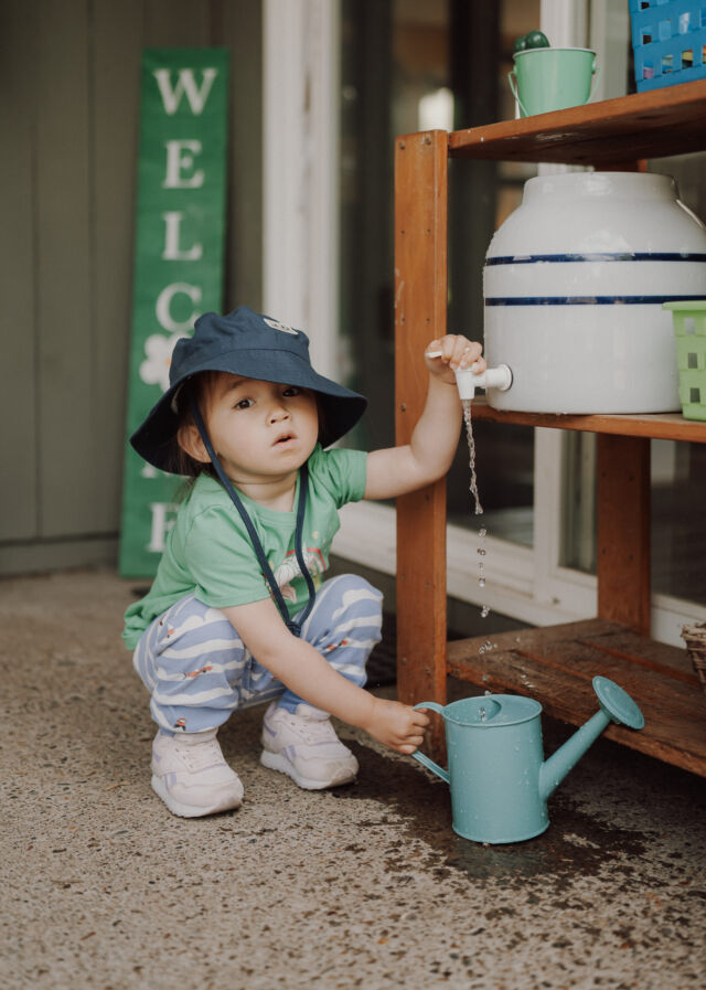 Filling a watering can at the water crock