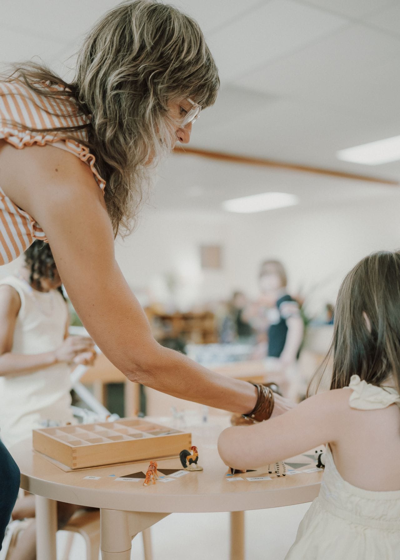 A guide works with a child at her eye level