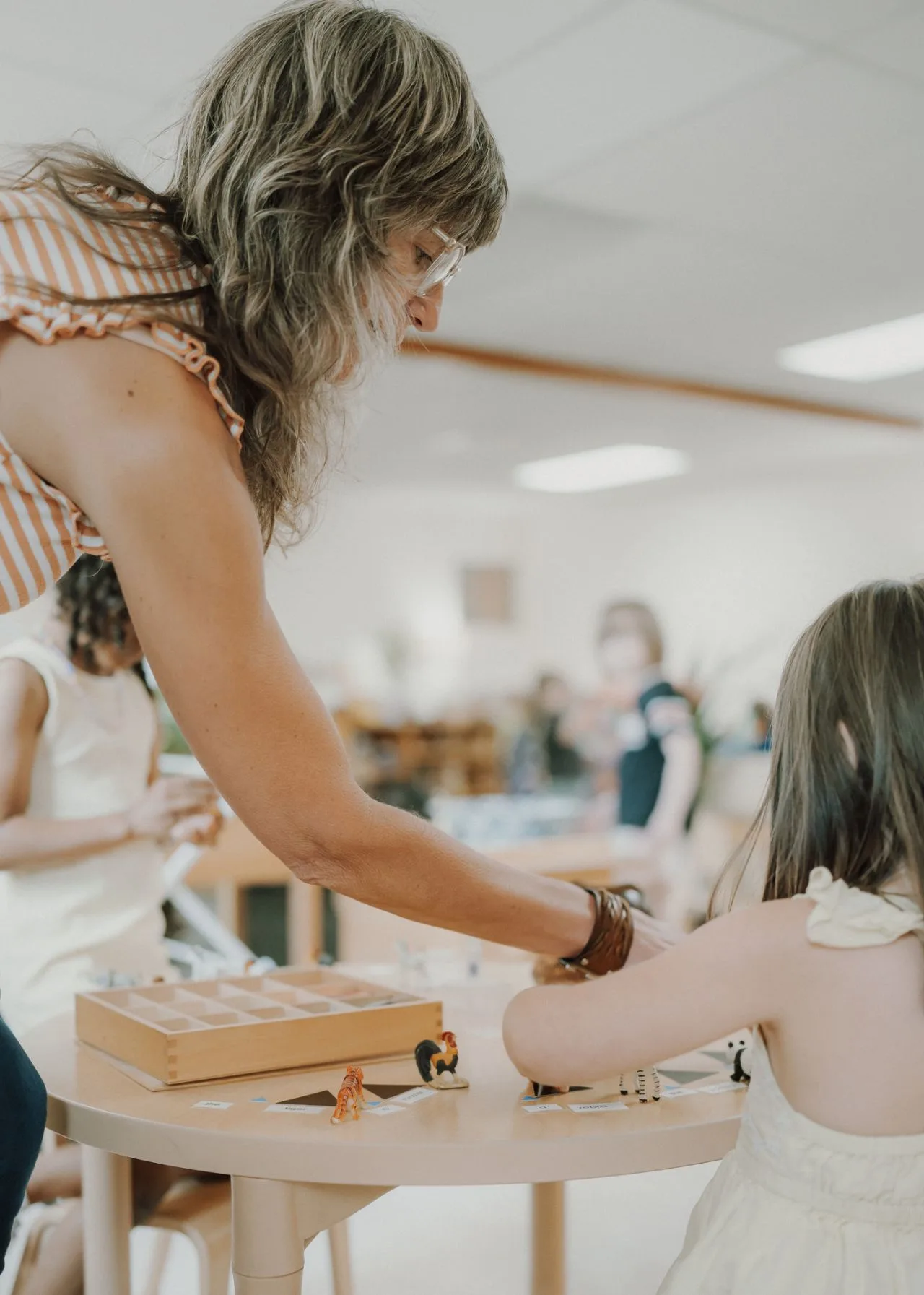 A guide works with a child at her eye level