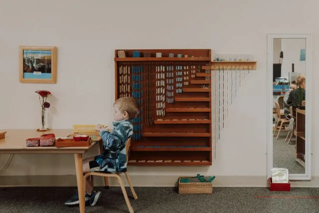 A child works at the bead cabinet